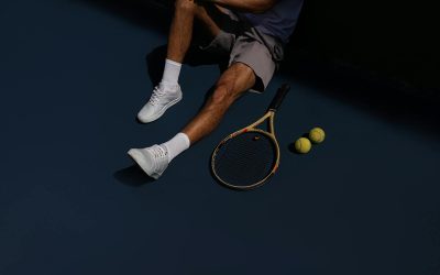 A tennis player resting on the court with racket and balls, in São Paulo, Brazil.