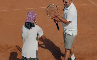 a man and a woman holding tennis rackets
