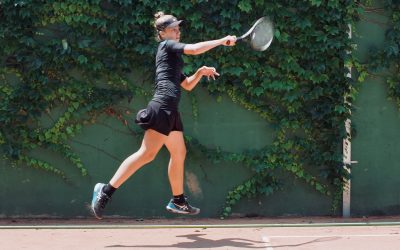 a woman in black shirt and shorts playing a game of tennis