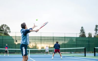 four men playing double tennis during daytime